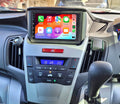 A touchscreen car stereo system installed in a vehicle's dashboard, displaying a colorful interface with icons for Apple CarPlay features.