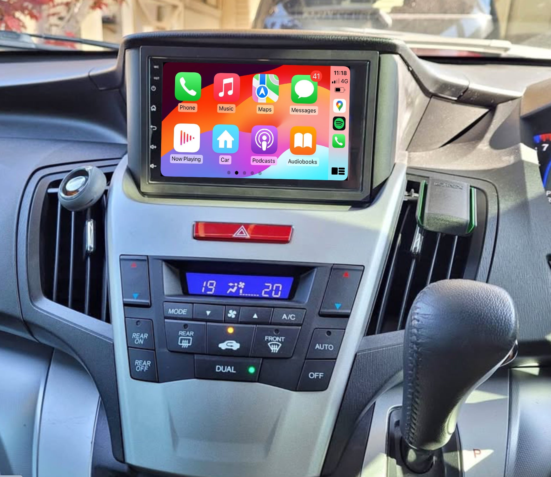 A touchscreen car stereo system installed in a vehicle's dashboard, displaying a colorful interface with icons for Apple CarPlay features.