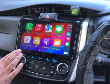 A touchscreen car stereo system displaying Apple CarPlay interface, installed in a vehicle's dashboard.