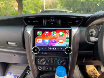 An aftermarket GPS wireless stereo system installed in a vehicle, featuring a touchscreen interface displaying Apple CarPlay screen.