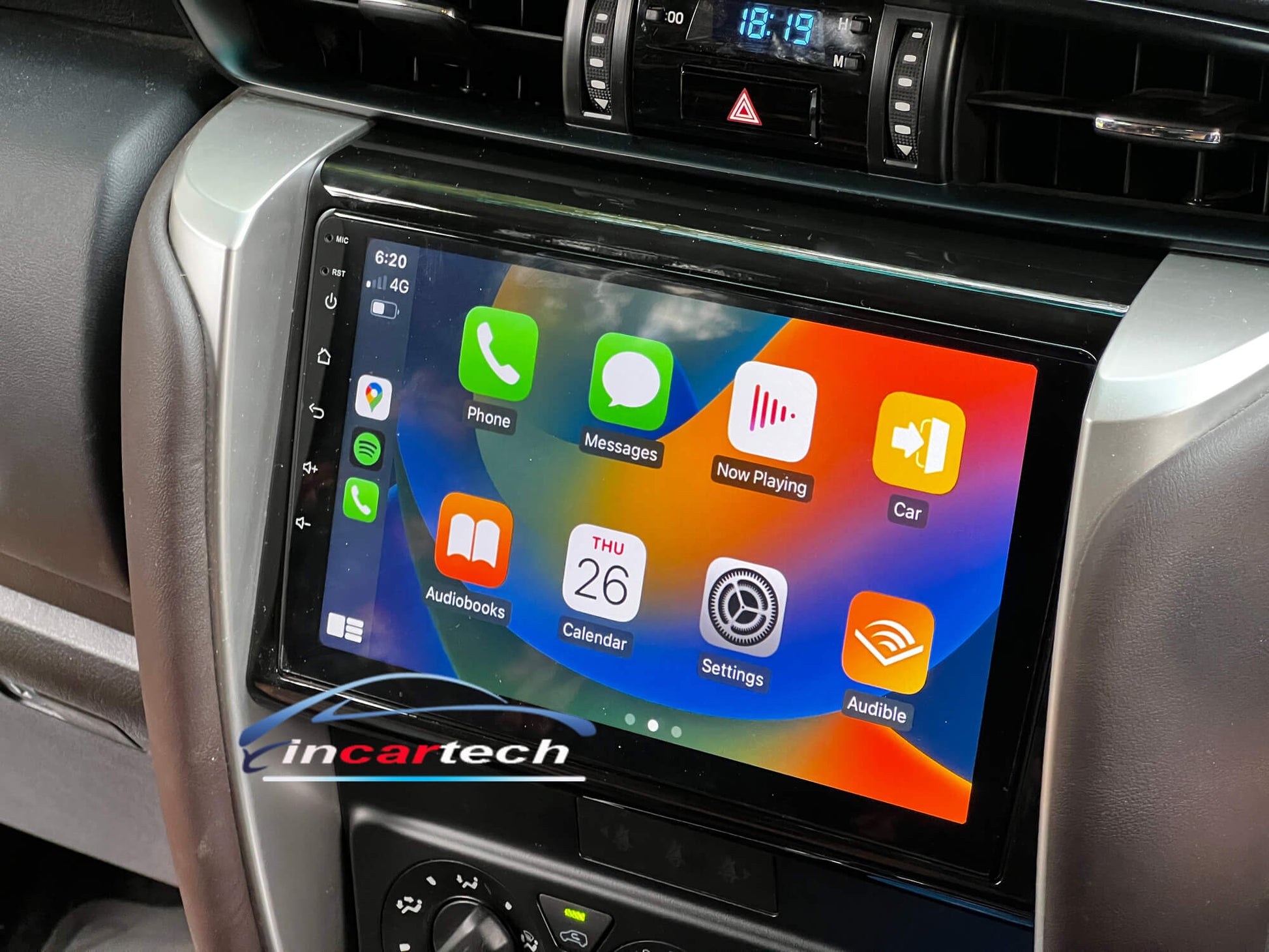 An aftermarket GPS wireless stereo system with a touchscreen interface installed in a vehicle, displaying Apple Carplay and Android Auto app icons.