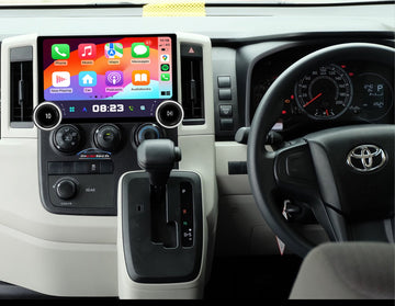 An aftermarket GPS wireless stereo radio interface installed in a Toyota Hiace vehicle, featuring a touchscreen display, dual knob control, and integration with the vehicle's steering wheel and dashboard.