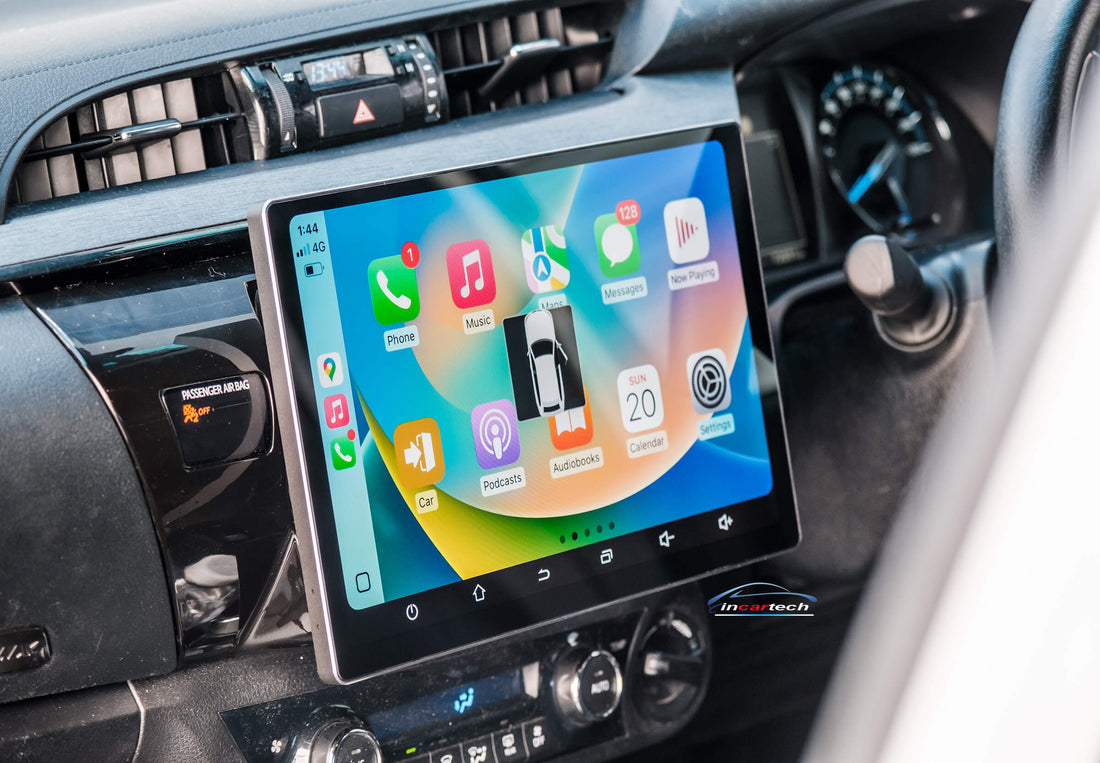 A 13.3 inch touchscreen car stereo system installed in a vehicle's dashboard, displaying a colorful interface with icons for Apple Carplay and Android Auto features.