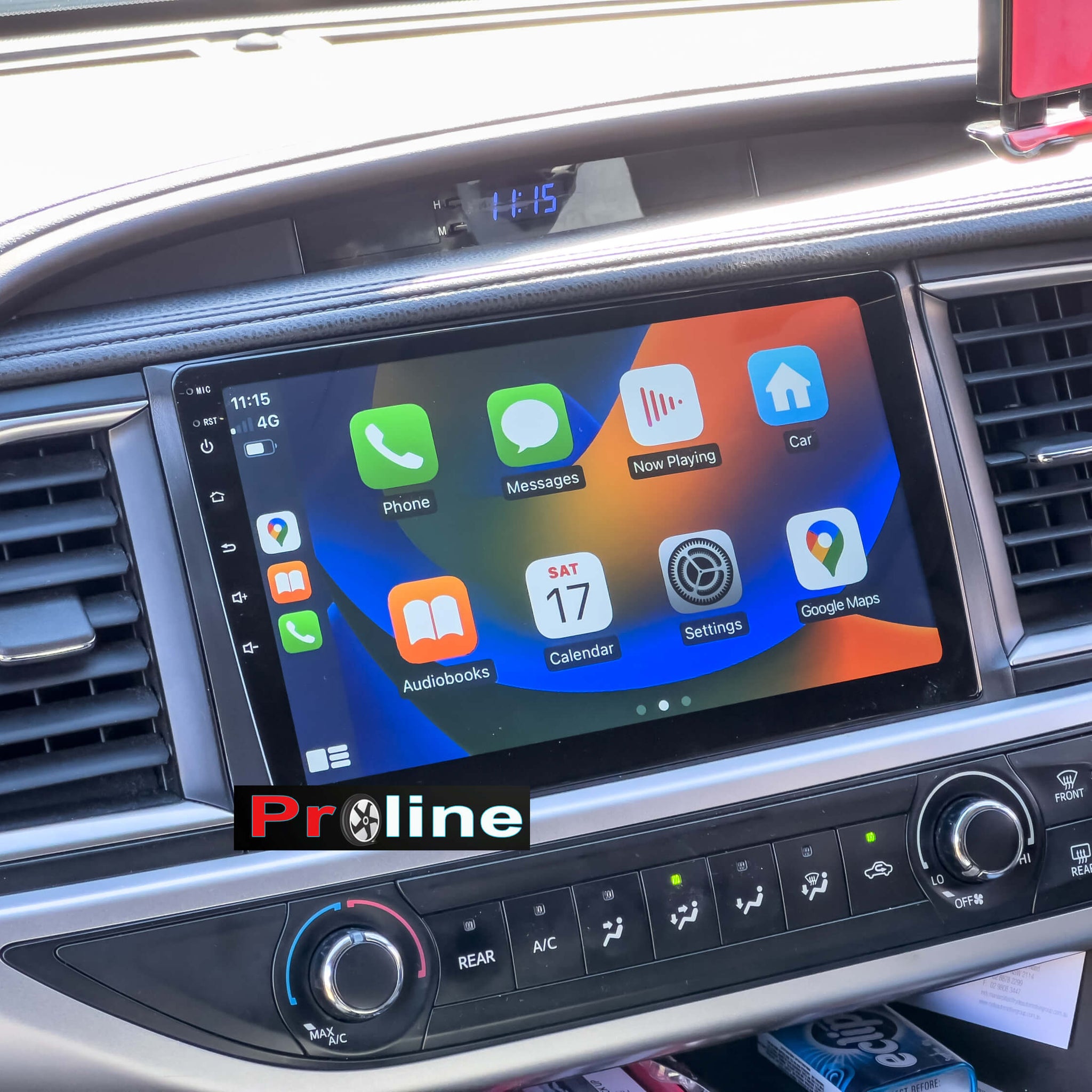 An aftermarket touchscreen car multimedia system installed in a vehicle, displaying a colorful interface with icons for Apple CarPlay and Android Auto features.