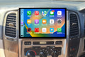 A 13.3-inch touchscreen car stereo installation in a vehicle's dashboard, displaying a colorful interface with icons for Apple CarPlay and Android Auto features.