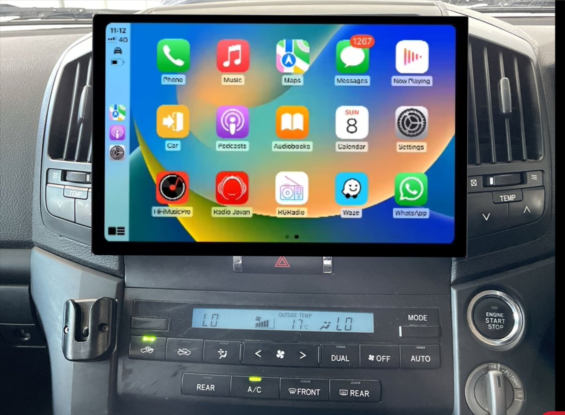 An aftermarket touch screen car stereo system interface displayed inside a vehicle's dashboard. The screen shows icons for Apple CarPlay and Android Auto features.